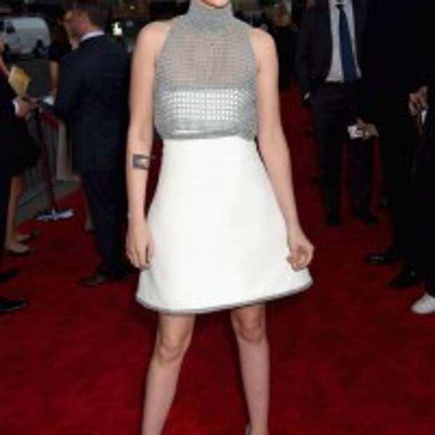 Kristen Stewart flared white skirt rising up gray crop top with pair of Casadei shoes