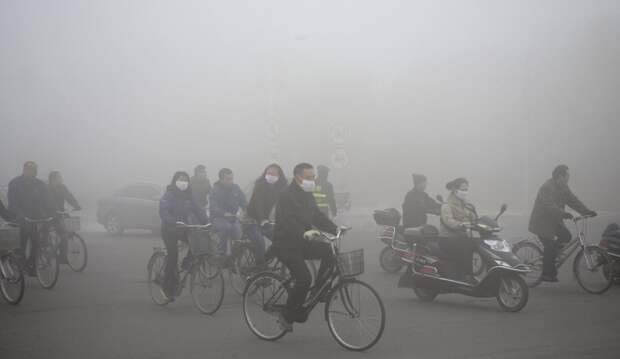 Группа велосипедистов и мотоциклистов носит маски, передвигаясь по улице в городском округе Дацин загрезнение, китай, природа