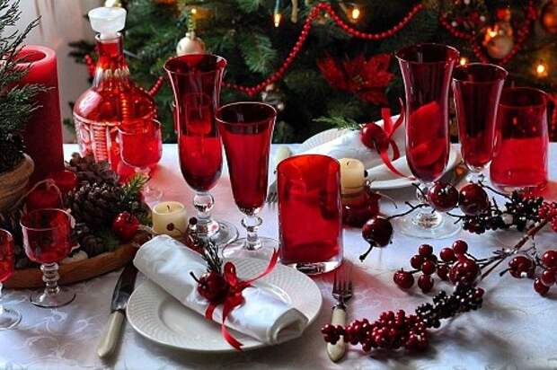 Красные ягоды, посуда глубокого насыщенного и глубокого оттенка, красные бусы и ленточки создают торжественное и праздничное настроение.