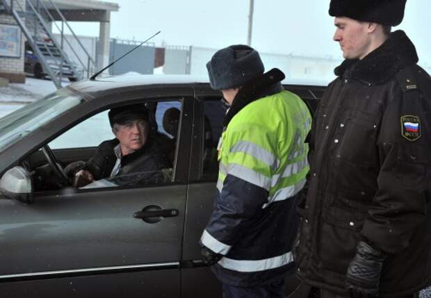 Инспектор ГИБДД проверяет автомобиль