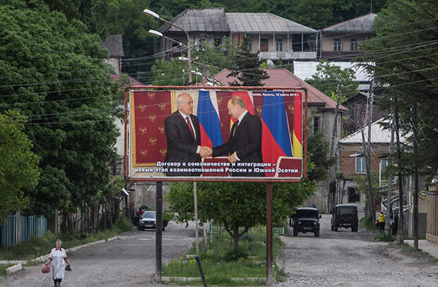 Плакат с изображением рукопожатия Л. Тибилова и В. Путина в Цхвинвале Фото: Станислав Красильников / ТАСС
