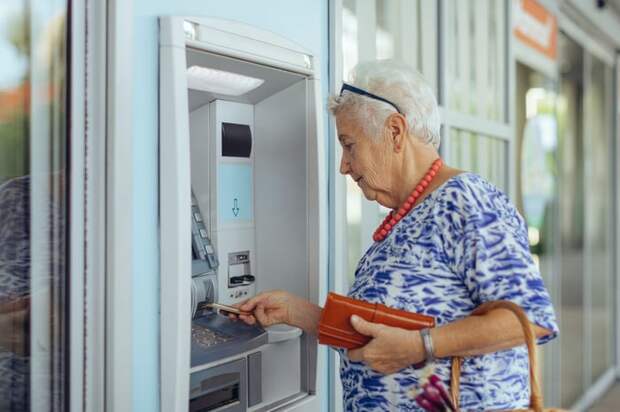 Person putting a card into an ATM.