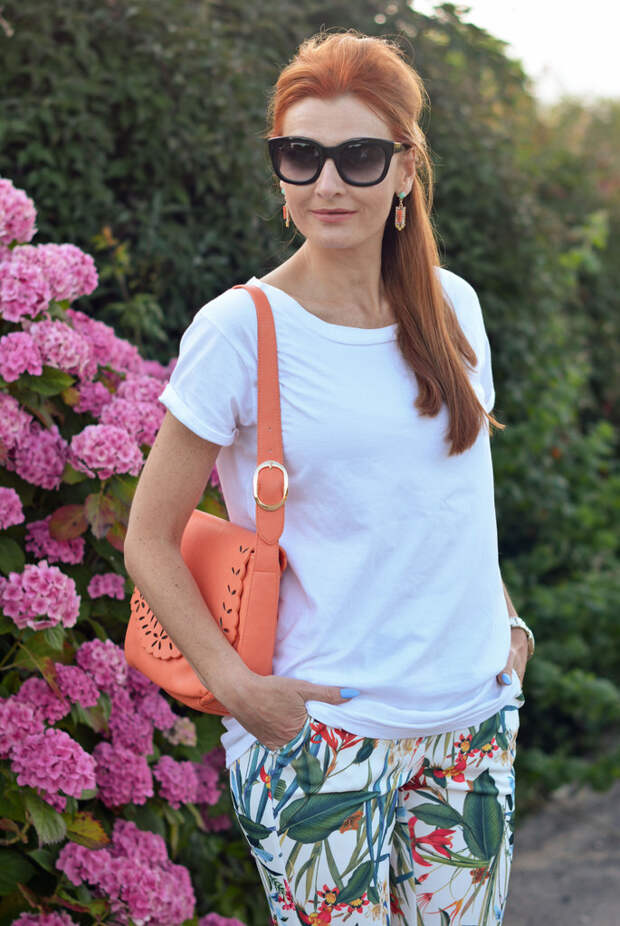 White boyfriend tee, tropical print trousers, peach bag