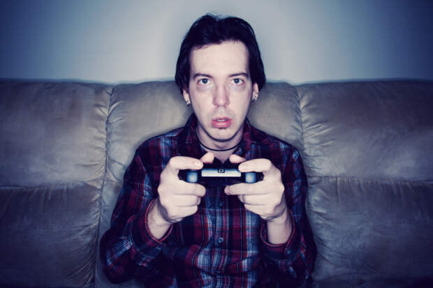 Зависимость от видеоигр: горькая правда, которую должен знать каждый родительMan sitting on a couch playing video games in a dark room