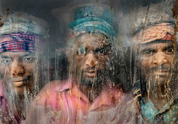 Рабочие смотрят через грязное стекло в Читтагонге, Бангладеш