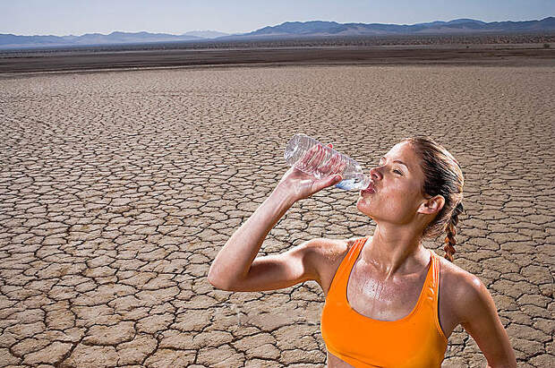 Runner Drinking Bottled Water in Desert --- Image by © Tim Tadder/Corbis
