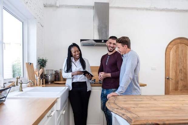 A realtor showing a smiling couple a new home.