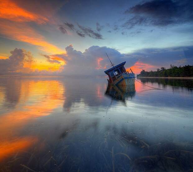 Затонувшая лодка на острове Борнео. Закат. Фото