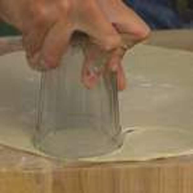 Присыпать рабочую поверхность мукой, раскатать тесто как можно тоньше и вырезать из него с помощью чашки или стакана небольшие кружки.