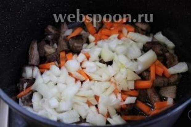 К мясу добавить соломку моркови и нарезанный лук.