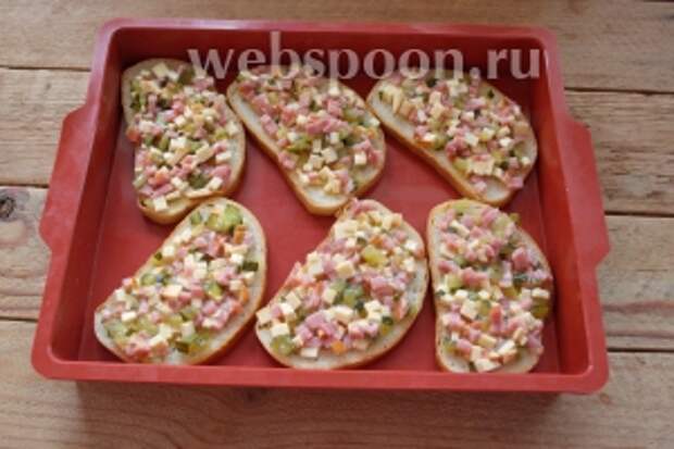 Полученную массу нанесите на одну сторону каждого кусочка батона. Уложите всё в форму. Если форма не силиконовая, то её лучше застелить бумагой для выпечки.