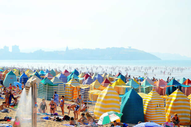 Кромешная тьма туристов на испанском пляже Плайя-де-Сан-Лоренцо во время летних отпусков