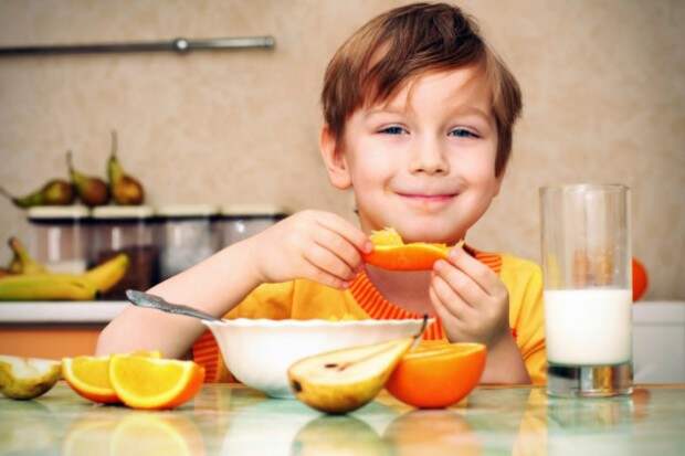 Мальчик кушает апельсин