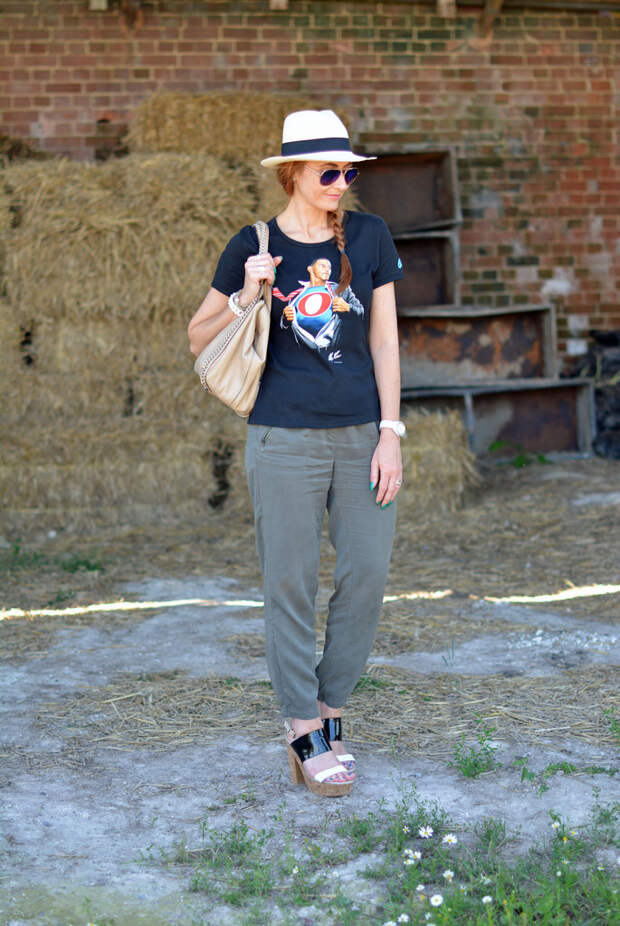 Black graphic tee with Panama hat, khaki track pants, strappy platforms