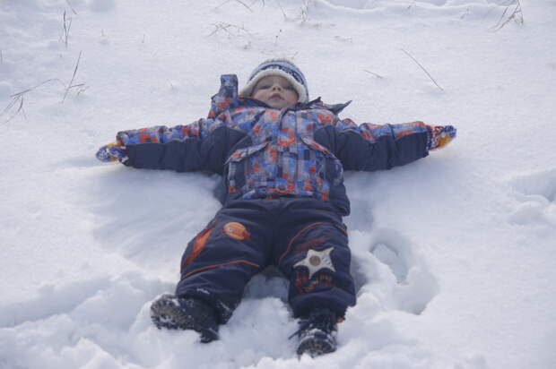 ребёнок лежит на снегу