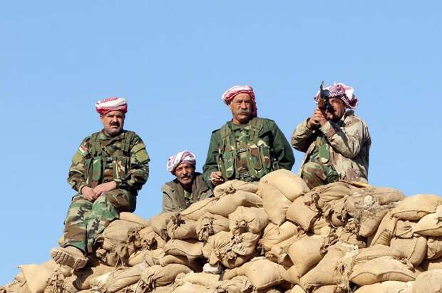 Members of the Kurdish peshmerga forces gather in the town of Sinjar