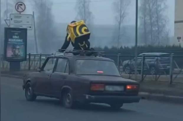 В Петербурге курьер проехался по шоссе на крыше автомобиля