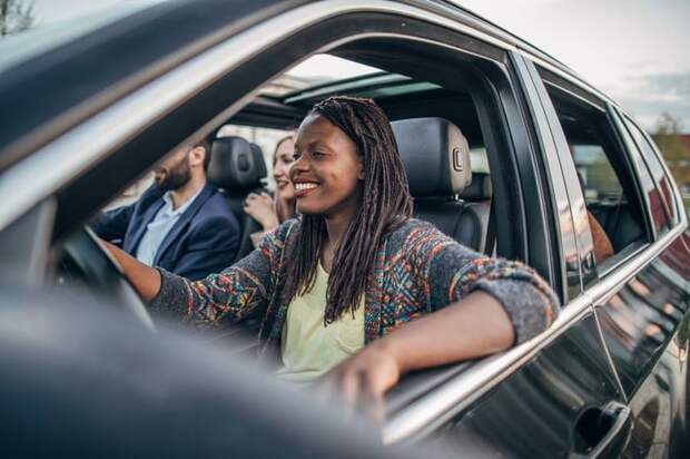 A woman driving a car with multiple passengers.