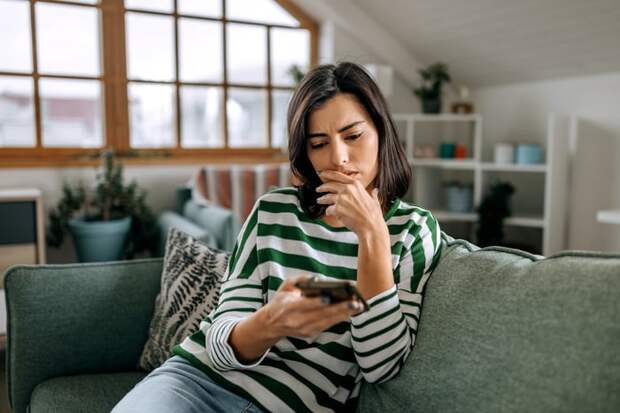 Worried person looking at smartphone.