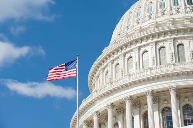 An American flag waving in front of the Capitol building in Washington, D.C.