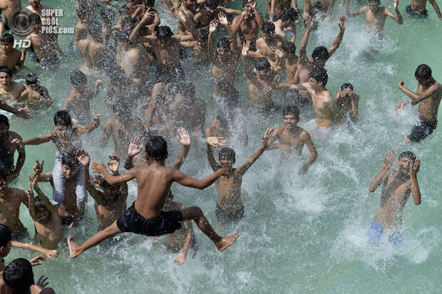 Пакистан. Лахор. Юноши освежаются в бассейне. (Arif ALI/AFP PHOTO)
