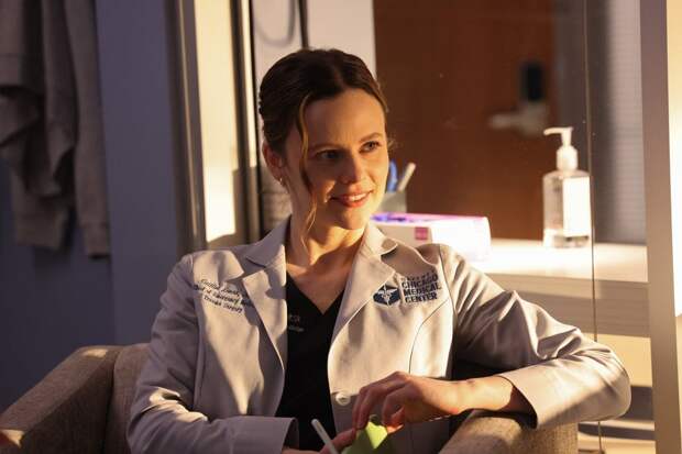 Lenox sitting in a chair smiling on Chicago Med Season 10 Episode 19