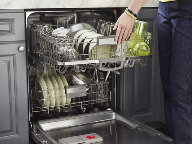 Загрузите посуду в посудомоечную машину и включите ее. / Фото: kitchenremont.ru