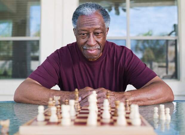 A person studying a chess board set out in front of them.