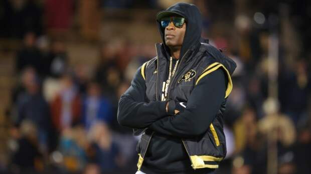 Deion Sanders stands on the field before a Colorado football game.