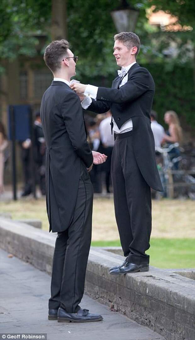 One guest dutifully helps his friend adjust his bow tie as they wait to make their way to the lavish Trinity May Ball