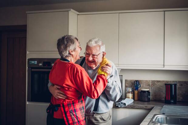 Two people dancing in a kitchen.