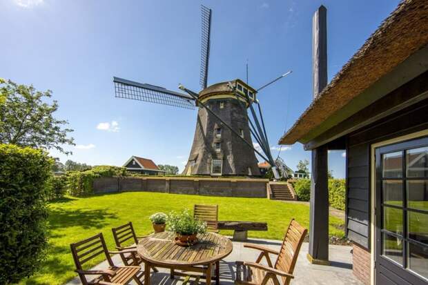 Старинная голландская мельница горделиво возвышается над восхитительным деревенским пейзажем.