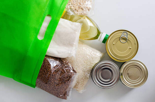 шельфа стабильные продукты упакованы в зеленый мешок. консервы и крупы - крупы в магазине стоковые фото и изображения