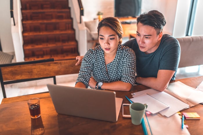 Serious couple looking at laptop together.