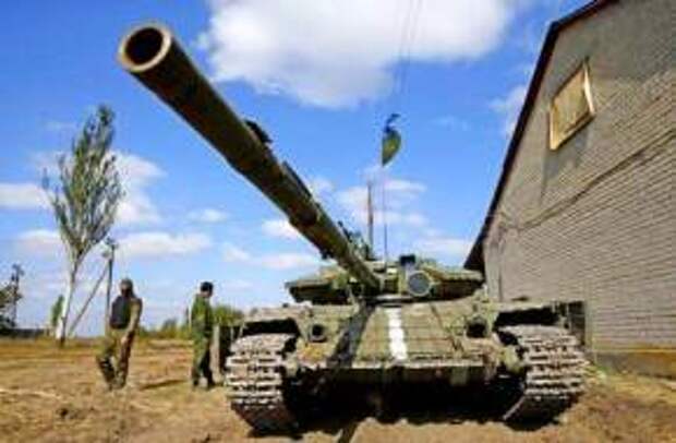 Ukrainian soldiers stand next to a tank near Donetsk