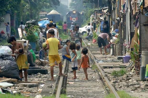 Филиппинские трущобы, прямо вдоль железной дороги, где буквально в метре от железнодорожных путей играют маленькие дети.