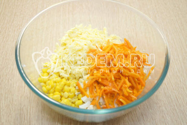 Добавить нарезанные кубиками яйца, тертый сыр и морковь по-корейски.