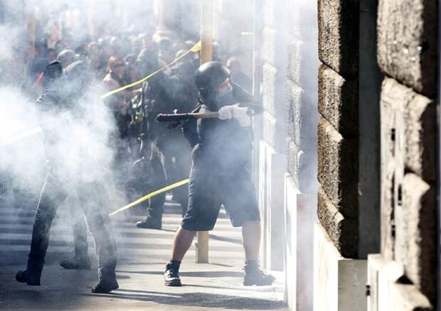 Demonstrators attempt to break through the entrance of a bank branch during a demonstration of the 'Indignant' group against banking and finance in Rome