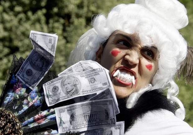 A demonstrator holds copies of U.S. ten dollar banknotes during a demonstration against banking and finance in Rome