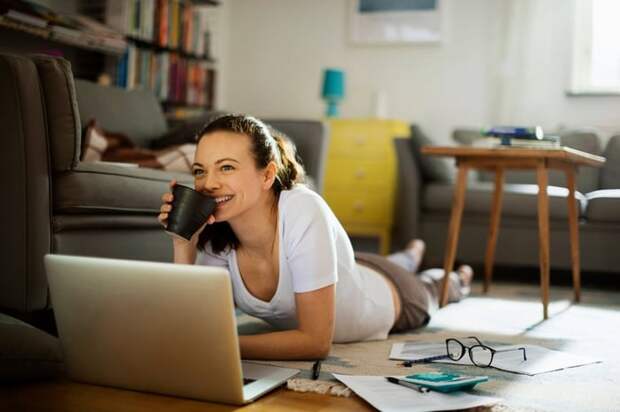 A woman pauses working on her personal finances to enjoy a cup of coffee.