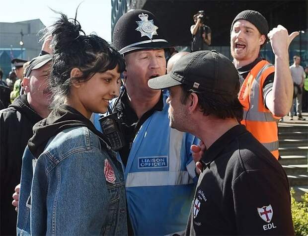 Мусульманка улыбается участнику демонстрации Лиги английской обороны (организации, выступающей против исламизации страны), Бирмингем, Англия демонстрации, женщины, кадры, общество, протест, сильные женщины, сильные фотографии, фото