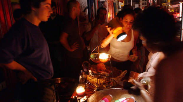 Люди покупают товары в магазине во время массового отключения электроэнергии в Нью-Йорке, 14 августа 2003 года 