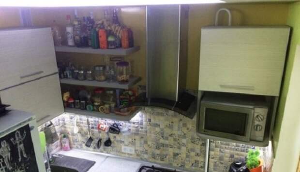 Пространство над холодильником задействовано навесными шкафами, сделанными из плит ДСП самим хозяином. | Фото: realty.tut.by.