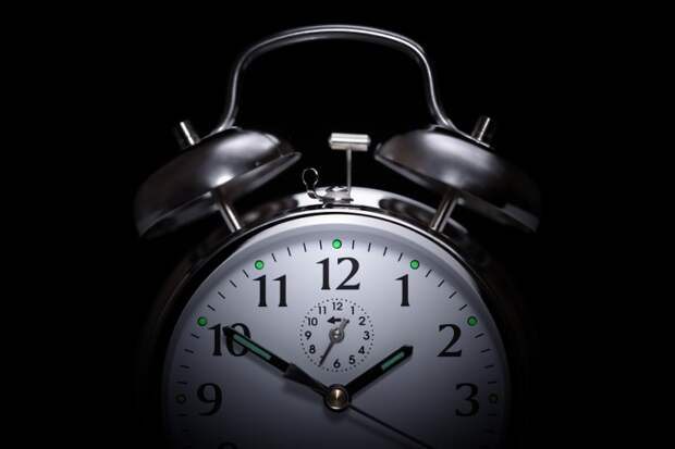 Alarm clock in the middle of the night isolated on black concep