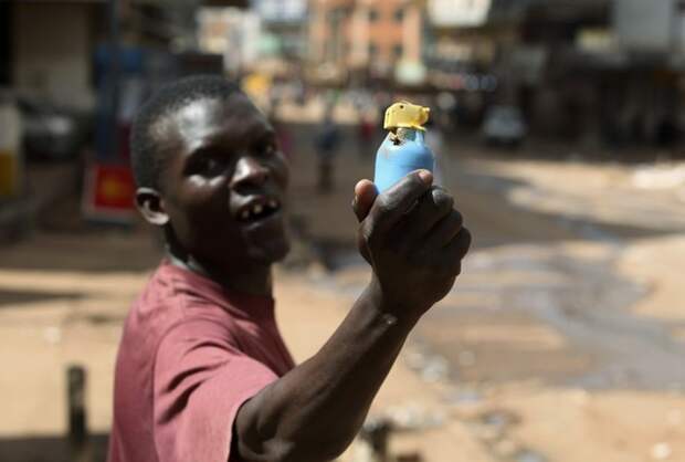 A man holds an empty teargas canister, which was fired at rioters, during demonstrations in Kampala