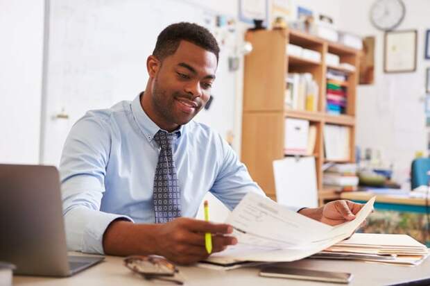 A man reading paperwork at his desk.