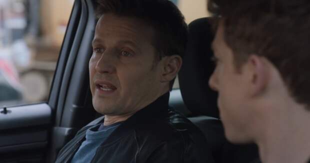 Joe looks at Jamie who is talking to him while riding together on Blue Bloods Season 14 Episode 11