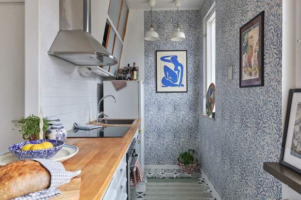 Атмосферу на кухне создают обои William Morris и распечатанные плакаты (у холодильника висит репродукция одной из самых популярных работ Анри Матисса)