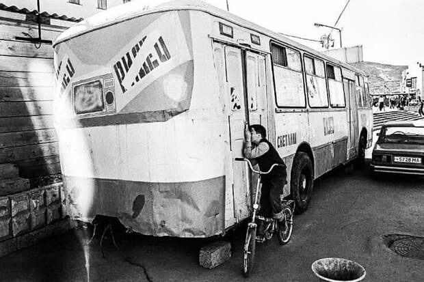 19. Мальчик подсматривает за показом фильма в видеосалоне, который находится в автобусе, Магадан, 1994 год