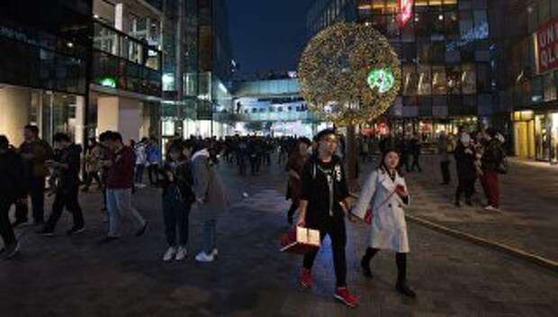 Горожане на территории многофункционального комплекса Sanlitun Soho в Пекине. Архивное фото